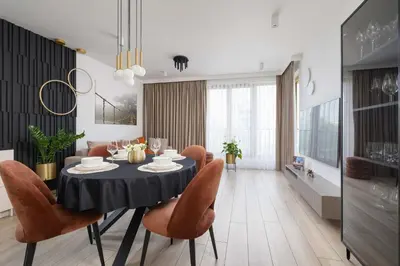 a dining room with a black table and orange chairs at Modern Prestige Apartment with Parking in Kraków by Noclegi Renters in Kraków