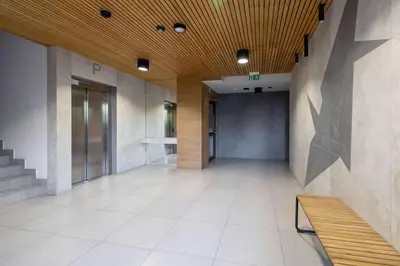 an empty hallway with a bench in a building at Light Grey Apartment in Cracow with Furnished Balcony by Noclegi Renters in Kraków