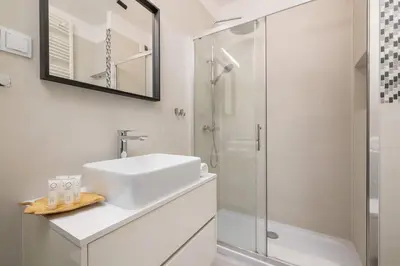 a white bathroom with a sink and a shower at Light Grey Apartment in Cracow with Furnished Balcony by Noclegi Renters in Kraków