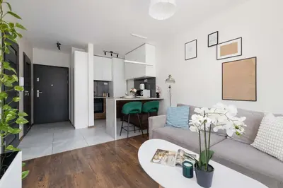 a living room with a couch and a table at Light Grey Apartment in Cracow with Furnished Balcony by Noclegi Renters in Kraków