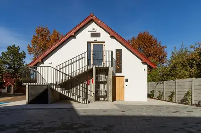 a white house with a staircase in front of it at Volare Balice in Cholerzyn
