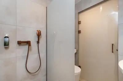 a bathroom with a shower with a phone on the wall at Volare Balice in Cholerzyn
