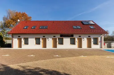 a large white building with a red roof at Volare Balice in Cholerzyn