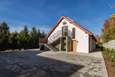 a house with a staircase in front of a driveway at Volare Balice in Cholerzyn