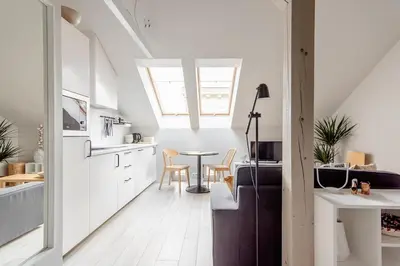 a kitchen and dining room with a table in a room at Charming designer attic in Kraków