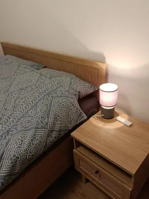 a bed with a night stand with a lamp on it at Podłęże Trawniki Industrial Zone