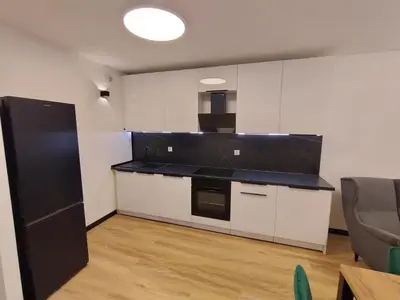 a kitchen with black counter tops and white cabinets at Podłęże Trawniki Industrial Zone
