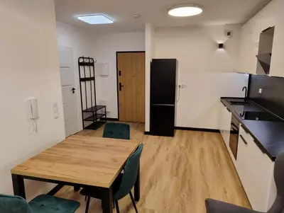 a kitchen with a wooden table and a refrigerator at Podłęże Trawniki Industrial Zone