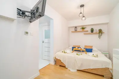 a bedroom with a bed and a tv on the wall at Kraków Apt - Top Location, Old Town Nearby - by Rentujemy in Kraków