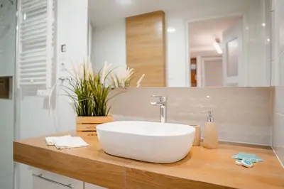 a bathroom with a white sink on a wooden counter at Kraków Apt - Top Location, Old Town Nearby - by Rentujemy in Kraków