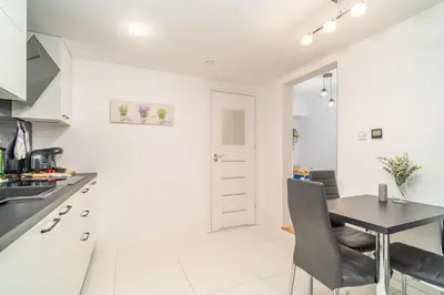 a kitchen with a table and a dining room at Kraków Apt - Top Location, Old Town Nearby - by Rentujemy in Kraków