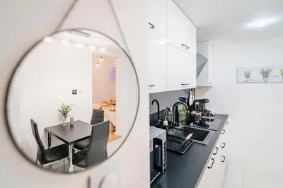 a kitchen and a dining room with a table in a mirror at Kraków Apt - Top Location, Old Town Nearby - by Rentujemy in Kraków