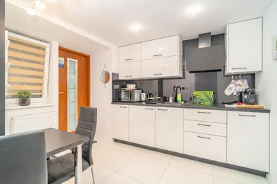 a kitchen with white cabinets and a table in it at Kraków Apt - Top Location, Old Town Nearby - by Rentujemy in Kraków