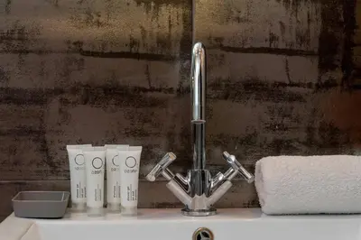 a sink with a faucet and two cups on it at Meiera Krakow Charming Apartment with Parking and Air Conditioning by Noclegi Renters in Kraków