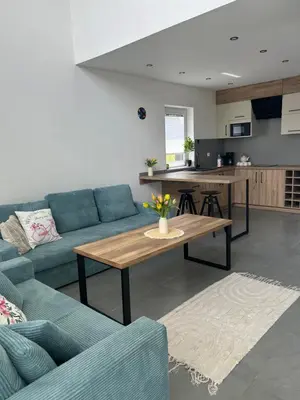 a living room with a blue couch and a table at 4 Żywioły-Noclegi w Beskidach basen sauna jacuzzi in Koziniec