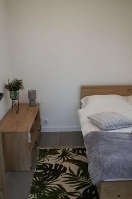a bedroom with a bed and a table and a rug at 4 Żywioły-Noclegi w Beskidach basen sauna jacuzzi in Koziniec
