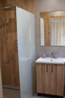 a bathroom with a sink and a shower with a mirror at 4 Żywioły-Noclegi w Beskidach basen sauna jacuzzi in Koziniec