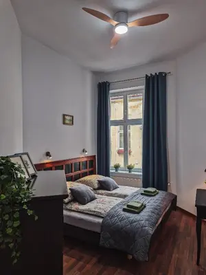 a bedroom with a bed and a ceiling fan at Old Town PLAC SZCZEPAŃSKI Premium Apartments in Kraków