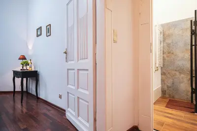 a hallway with a white door and a table at Old Town PLAC SZCZEPAŃSKI Premium Apartments in Kraków