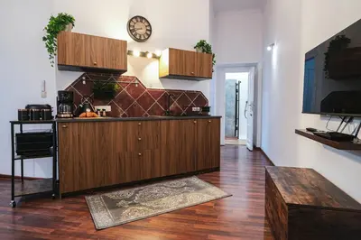 a kitchen with a counter and a clock on the wall at Old Town PLAC SZCZEPAŃSKI Premium Apartments in Kraków