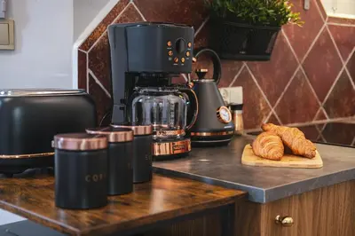 a counter with a coffee maker and croissants on it at Old Town PLAC SZCZEPAŃSKI Premium Apartments in Kraków