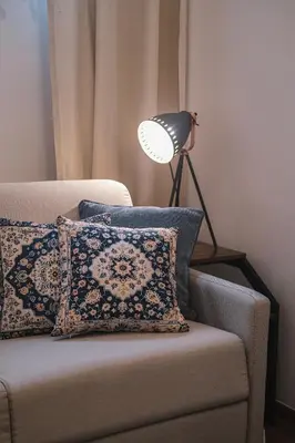 a lamp sitting on top of a couch with pillows at Old Town PLAC SZCZEPAŃSKI Premium Apartments in Kraków