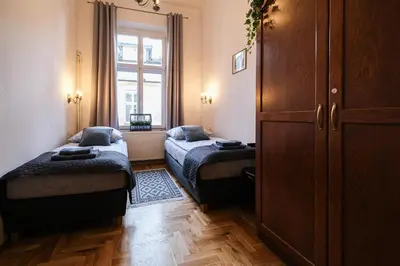 a small room with two beds and a window at Old Town PLAC SZCZEPAŃSKI Premium Apartments in Kraków