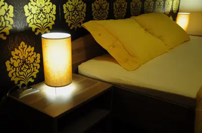 a bedroom with a bed and a table with a lamp at Color Apartment in Kraków