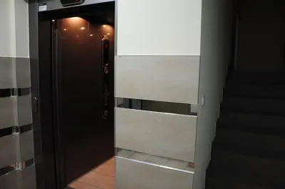 a hallway with an open door with a staircase at Color Apartment in Kraków