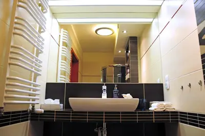 a bathroom with a sink and a large mirror at Color Apartment in Kraków
