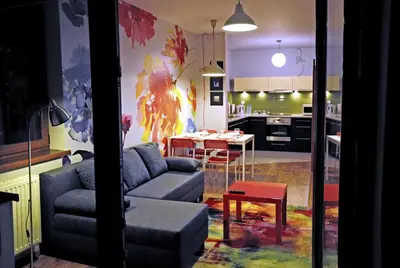 a living room with a couch and a table in a kitchen at Color Apartment in Kraków