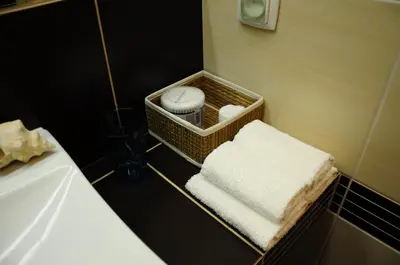 a bathroom with a basket of towels and a sink at Color Apartment in Kraków