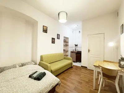 a bedroom with a bed and a table and a chair at Cozy Asnyka in Kraków