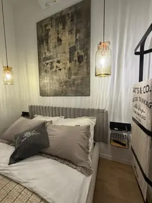 a bedroom with a bed with two pillows on it at Green Harmony Apartment in Kraków