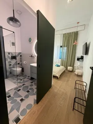 a room with a bathroom with a toilet and a bedroom at Green Harmony Apartment in Kraków