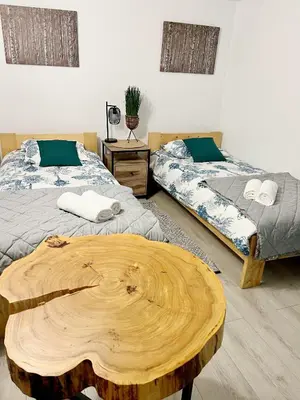 a room with two beds and a wooden table at Gorczańska Przystań in Zasadne