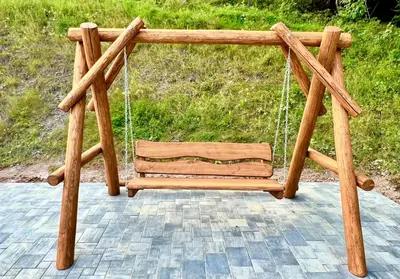 a wooden swing sitting on top of a patio at Gorczańska Przystań in Zasadne