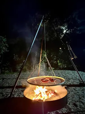 a pizza cooking on a fire in a pot at Gorczańska Przystań in Zasadne