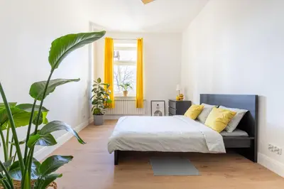 a bedroom with a bed with yellow pillows and a plant at ANTA Salt Mine City in Wieliczka