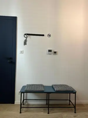 a table in front of a white wall with a lamp at Blue Harmony Apartment in Kraków