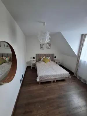 two beds in a room with wooden floors at Apartamenty TUTERRA IV in Zabagnie