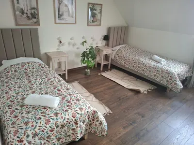 a bedroom with a bed and a table on a wooden floor at Apartamenty TUTERRA IV in Zabagnie