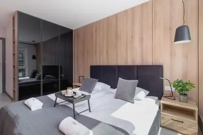 a bedroom with a large bed and a table at Elegant & Bright Apartment Zabłocie by Renters Prestige in Kraków