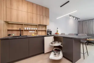 a kitchen with wooden cabinets and a counter top at Elegant & Bright Apartment Zabłocie by Renters Prestige in Kraków