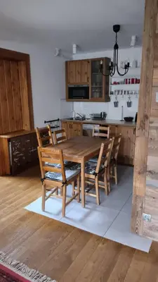 a kitchen with a wooden dining table and chairs at Cozy Apartment in Krakow in Kraków