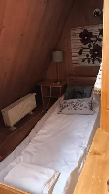 a large white bed in a wooden room at Cozy Apartment in Krakow in Kraków