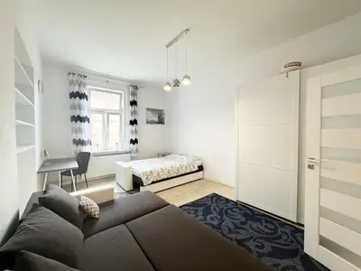 a bedroom with a couch and a bed and a desk at White & Black - near Wawel Castle in Kraków