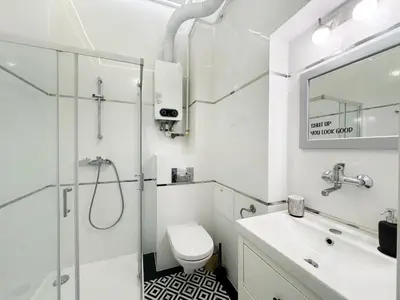 a bathroom with a shower and a toilet and a sink at White & Black - near Wawel Castle in Kraków