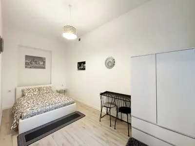a white bedroom with a bed and a desk at White & Black - near Wawel Castle in Kraków