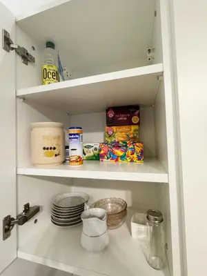 a white kitchen pantry with food and dishes at White & Black - near Wawel Castle in Kraków